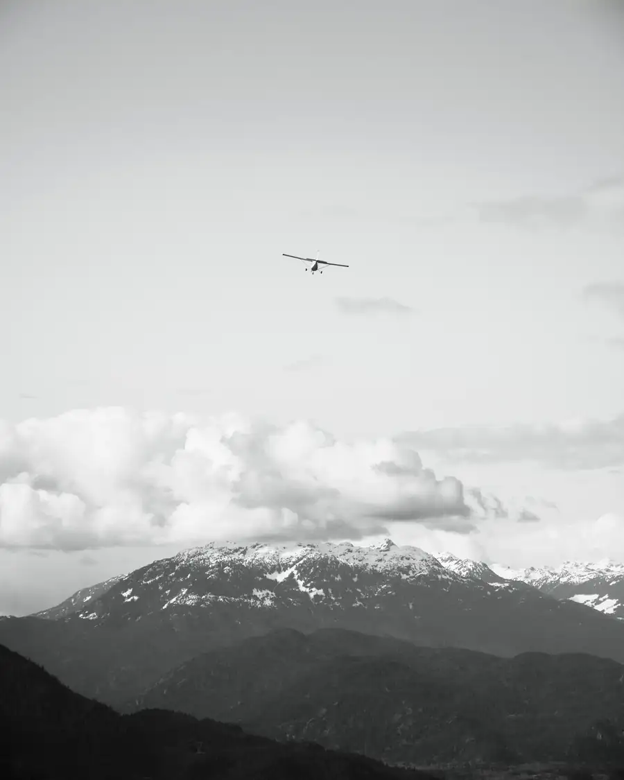 Airplane flying above clouds and mountains